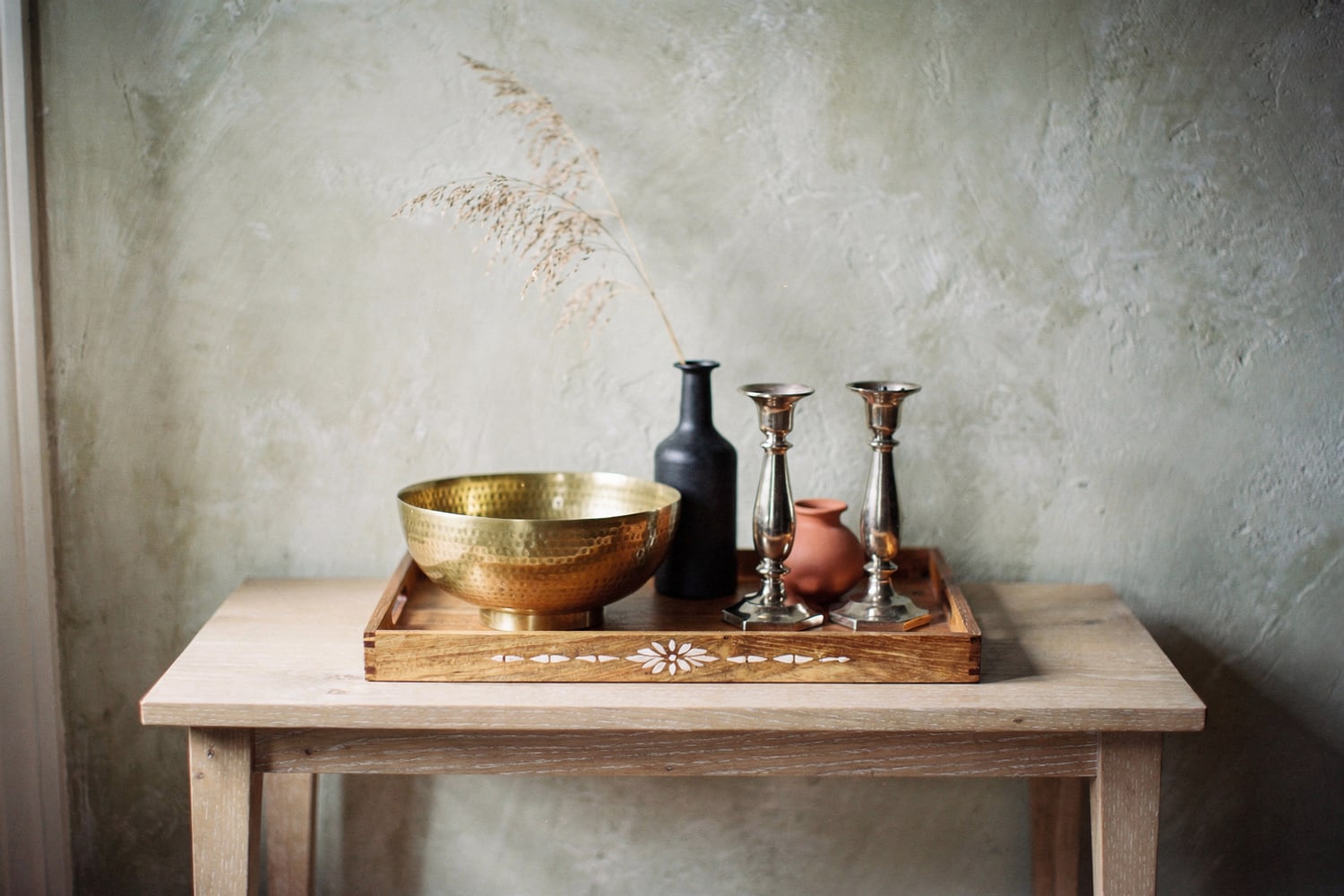 A hero lifestyle shot for a presentation cover: brass and iron décor styled on a console, rendered