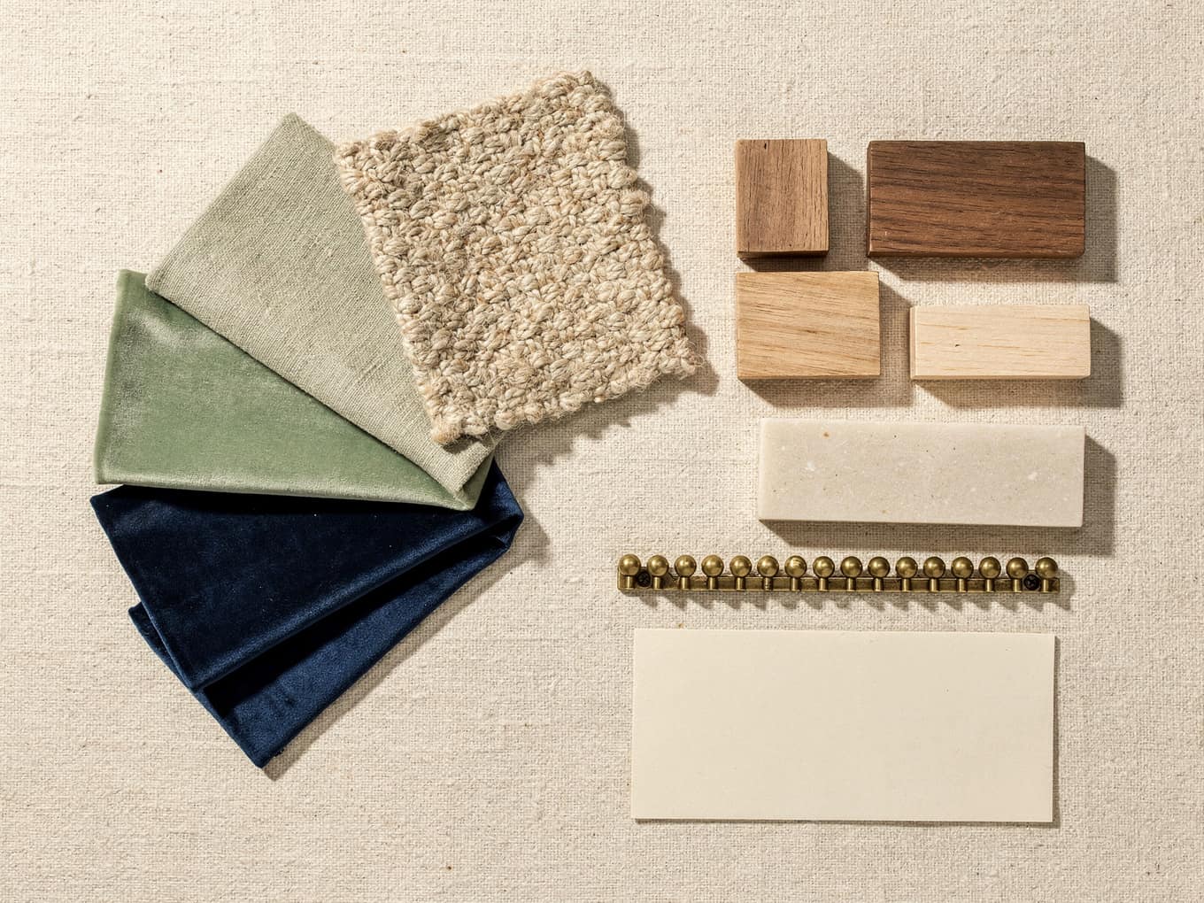 A maker’s mood board: graded fabric swatches, walnut and oak finish chips, a nailhead strip, rendered